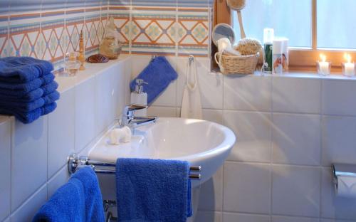 Ferienhäuser Bellana的浴室设有白色水槽和蓝色毛巾。