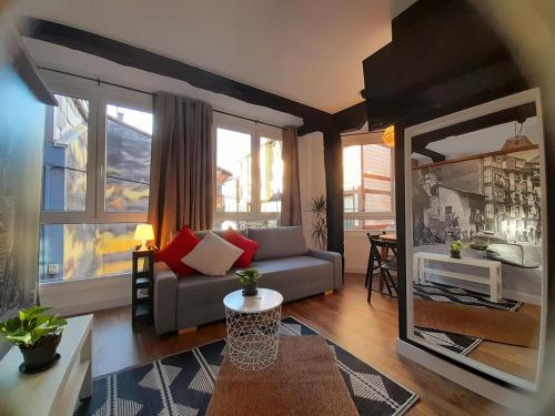 贝梅奥Andra Mari Apartamentu Turistikoak的带沙发的客厅和部分窗户。