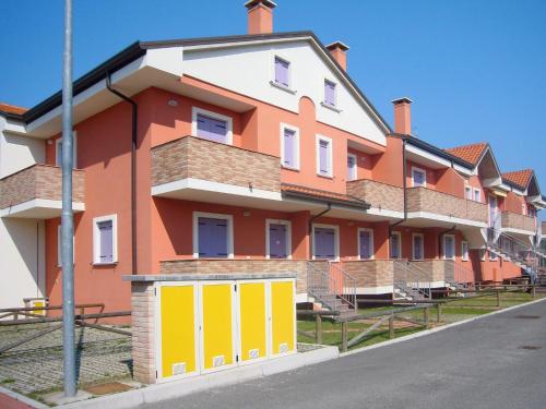 洛萨皮内塔Apartment Solmare-10 by Interhome的一条橙色和白色的建筑,街道上设有黄色门