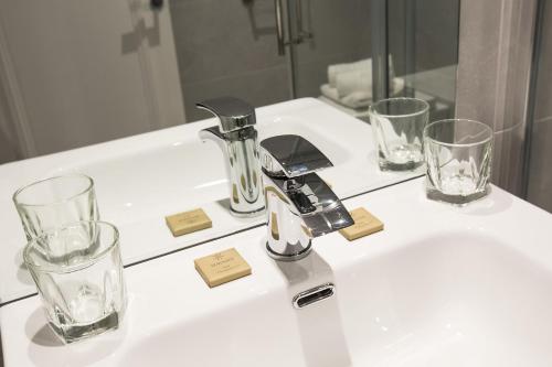 韦斯特米斯Castle Varagh Hotel & Bar的浴室水槽配有两杯玻璃和水龙头