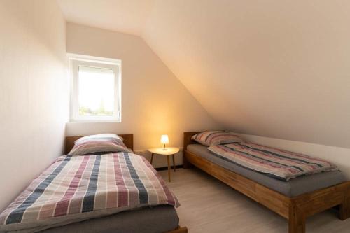 SüdbrookmerlandFerienwohnung 140 qm OstfrieslandNordsee für 1-6 Personen - Südbrookmerland的阁楼卧室设有两张单人床和窗户。