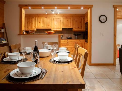 威拉尔-苏-罗伦Apartment Ambre 1 by Interhome的厨房配有木桌、盘子和酒杯