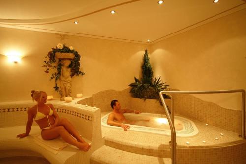 瓦尔道拉Appartements Steiner的男人和女人坐在浴室的浴缸里