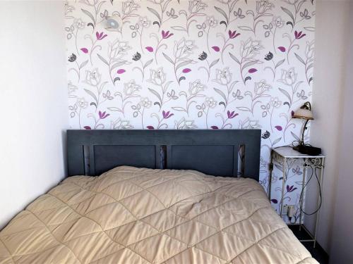 佩罗斯-吉雷克Appartement Perros-Guirec, 2 pièces, 4 personnes - FR-1-368-151的一间卧室配有一张带花卉壁纸的床