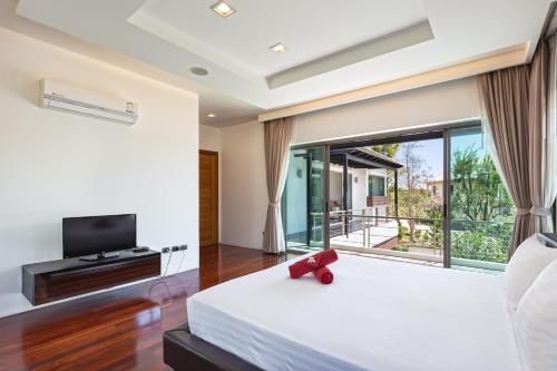 查龙Villa Piyada的一间卧室设有一张床和一个大窗户