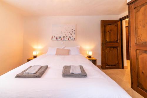 梅杰夫Cozzy appart dans chalet vue Mont-Blanc 2 chambres的卧室配有白色的床和2条毛巾