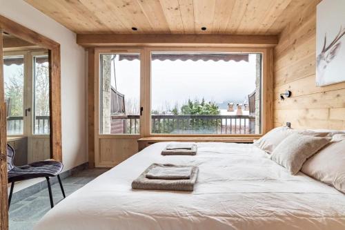 梅杰夫Cocon au pied des pistes de ski du Mont-d'Arbois的一间卧室设有一张大床和一个大窗户