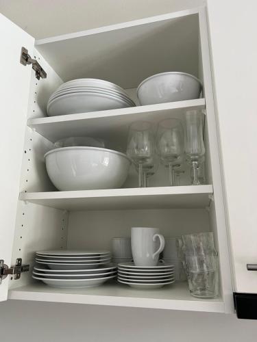 弗利姆斯Studio Flims的白色的橱柜,有盘子和杯子,盘子