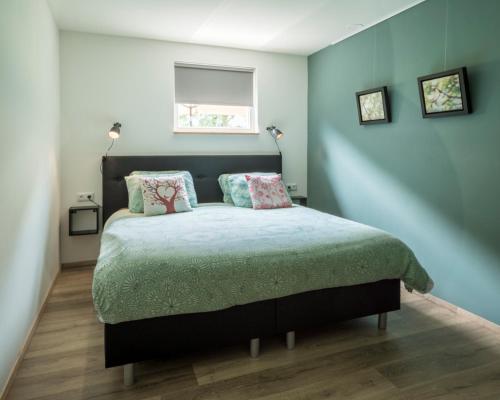 GrashoekIn de 7e Hemel的卧室配有带枕头的床铺和窗户。