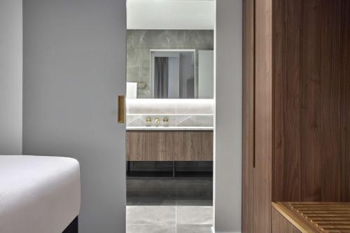墨尔本Adina Apartment Hotel Melbourne, Pentridge的一间带水槽和镜子的浴室