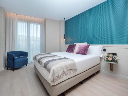 巴塞罗那ARCELON HOTEL - 10 min walking to Sagrada Familia的一间卧室设有一张大床和蓝色的墙壁