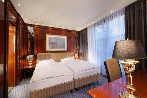 富尔达玛丽蒂姆富尔达酒店的一间卧室配有一张床和一张带台灯的桌子