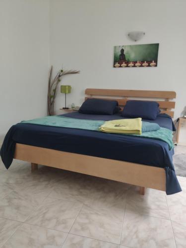 明德卢Maderalzinho的一间卧室配有一张带蓝色枕头的床