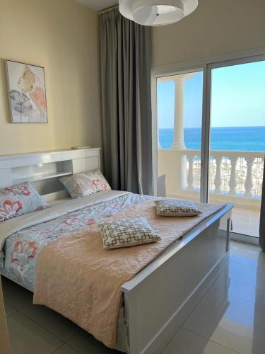 拉斯阿尔卡麦Royal Breeze view的一间卧室设有一张床,享有海景