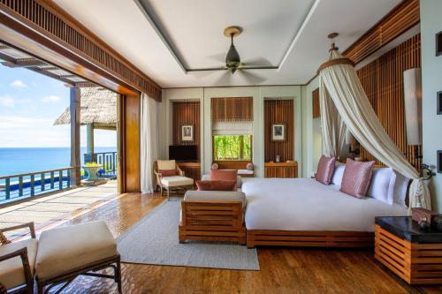 马埃岛Anantara Maia Seychelles Villas的一间卧室设有一张床和一个阳台
