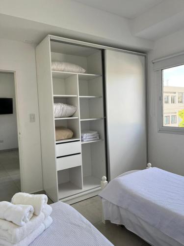 贝纳多图埃托Apart hotel Magda的卧室配有带枕头的白色衣柜和1张床。