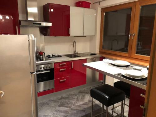 布鲁尼科Appartamento nuovo e comfort a Brunico Kronplatz的厨房配有红色橱柜和不锈钢冰箱
