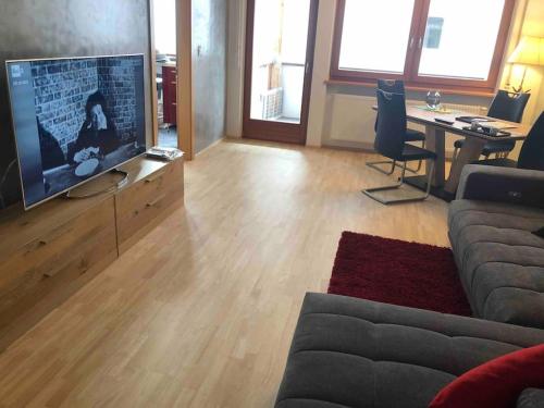 布鲁尼科Appartamento nuovo e comfort a Brunico Kronplatz的带沙发、电视和桌子的客厅