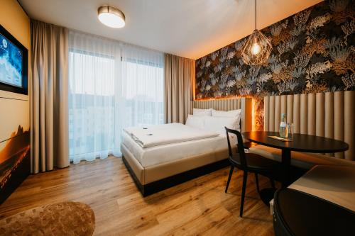 新乌尔姆Rioca Neu-Ulm Posto 5的酒店客房配有一张床铺和一张桌子。