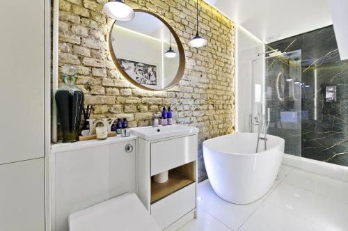 伦敦Stunning one bedroom flat with large terrace in Chiswick by UnderTheDoormat的浴室设有白色水槽和镜子