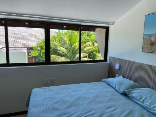 嘎林海斯港Muro alto Bangalô beach class ecolife的一间卧室设有一张床和一个大窗户