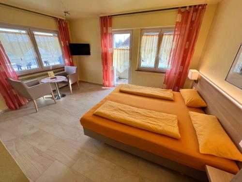 戈特马丁根Hotel-Heilsberg的一间卧室设有两张床、一张桌子和窗户。