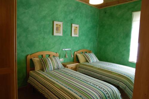 Soto y AmíoLa formigana的卧室设有两张床铺和绿色的墙壁
