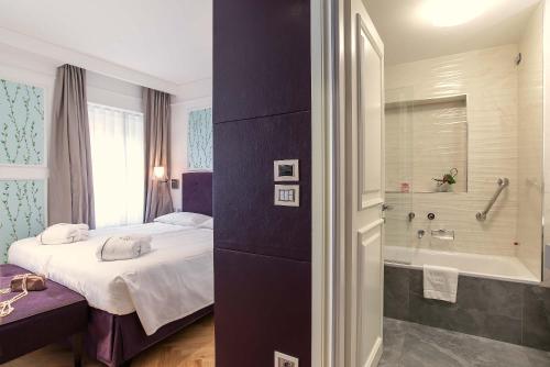 罗马达马索酒店的一间卧室配有一张床和浴缸