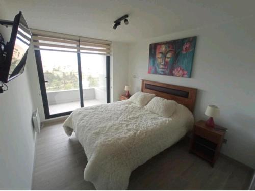 康康Hermoso Departamento dunas de concon的一间卧室设有一张床和一个大窗户