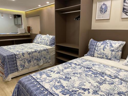 皮帕Pipa's Bay - Flats para temporada的一间卧室配有两张带蓝白色床单的床