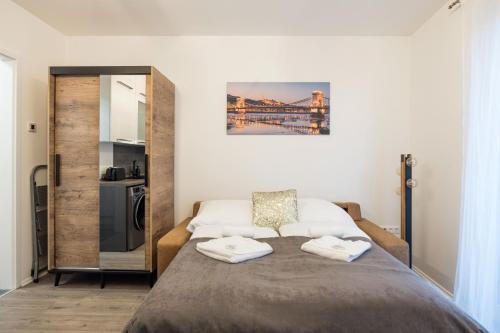 布达佩斯Central Sphere Apartment的一间卧室配有一张床,上面有两条毛巾