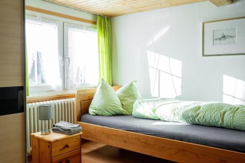 Sankt PeterzellGästehaus Aemisegg的一间卧室配有一张带绿色枕头的床和一扇窗户