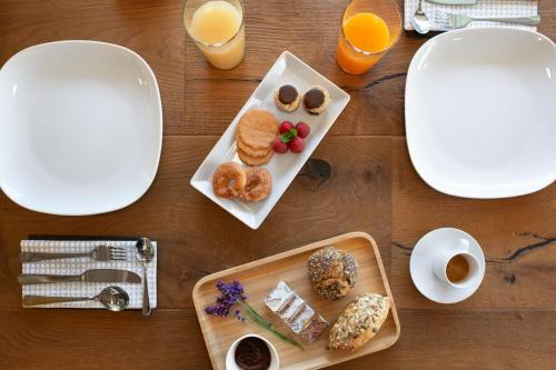 奥斯塔21Barra5 Guest House的一张桌子,上面放着一盘早餐食品和橙汁