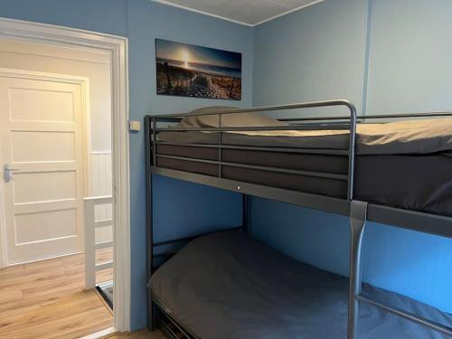 吕伐登Appartement centrum Leeuwarden的蓝色客房中的两张双层床,设有门
