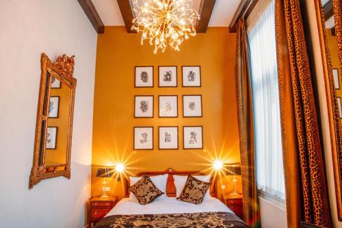 阿姆斯特丹大使酒店的一间卧室配有一张床、镜子和吊灯