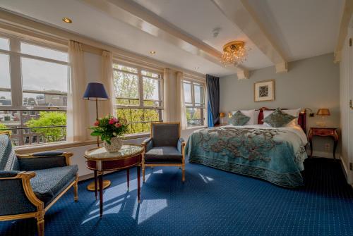 阿姆斯特丹大使酒店的卧室配有一张床和一张桌子及椅子