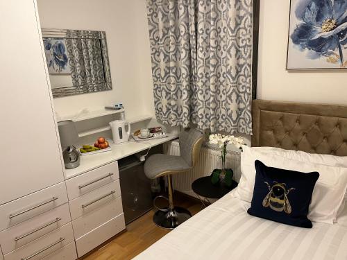 莱斯里普TJ Homes - Double room with Single Bed - 3 Min to Tube station - London的一间小卧室,配有一张床和一张书桌