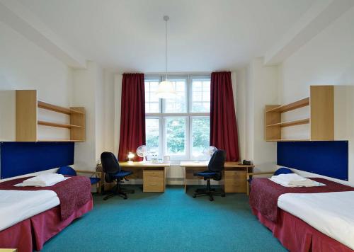 伦敦贝特庄园酒店的客房设有两张床、一张桌子和一个窗户。