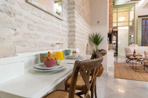 塞维利亚Judería de Sevilla I Luxury Apartments的用餐室配有餐桌和食物
