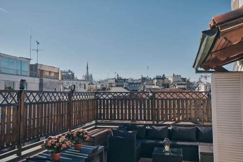 米兰Sant’Andrea Penthouse by Montenapoleone Living的阳台配有沙发,享有城市景观