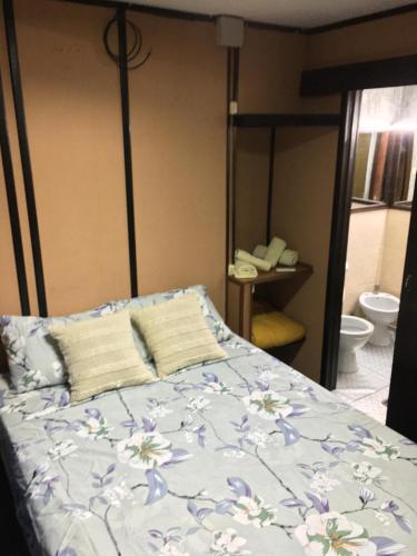 科洛尼亚-德尔萨克拉门托Hostel Parece Mentira的一间卧室配有一张带花卉床罩的床
