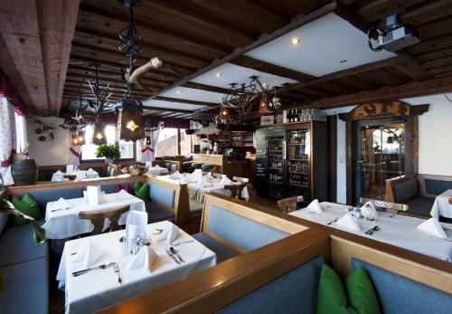 格罗萨尔阿尔卑霍夫酒店的一间设有白色桌椅的用餐室