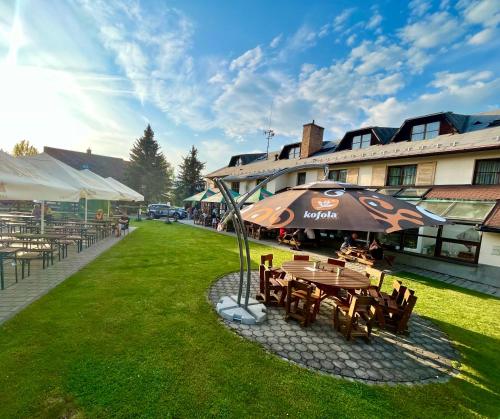 耶塞尼克Hotel STARÝ MLÝN的大楼旁带雨伞的野餐桌