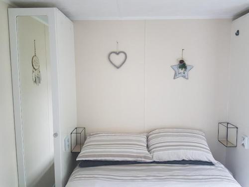 诺丁汉Lovely 2-Bed Chalet at Robinhood Retreat Free park的白色卧室配有一张位于墙上的心床