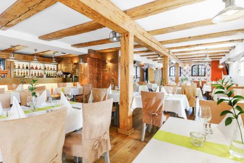 格但斯克格但斯克精品酒店的餐厅设有白色的桌椅和木制天花板。