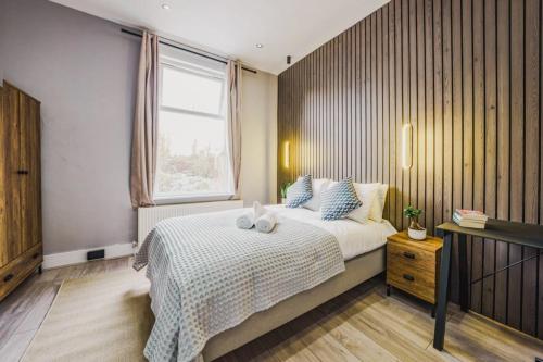 伦敦Modern apartment near Wembley Stadium的一间卧室设有一张大床和一个窗户。