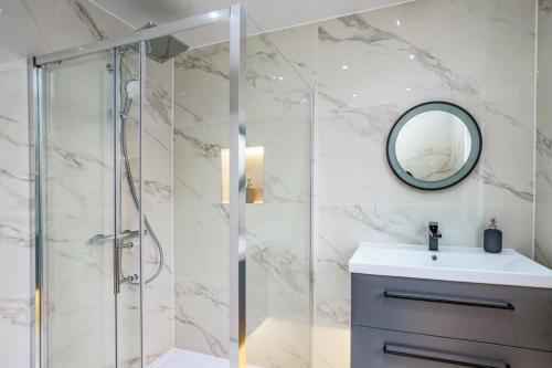 伦敦Modern apartment near Wembley Stadium的带淋浴、盥洗盆和镜子的浴室