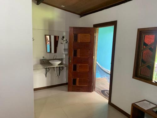伦索伊斯Pousada e Camping Lumiar的浴室设有门、水槽和镜子
