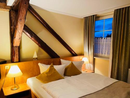 塔勒Harzhotel Warnstedter Krug的一间卧室设有一张大床和大窗户