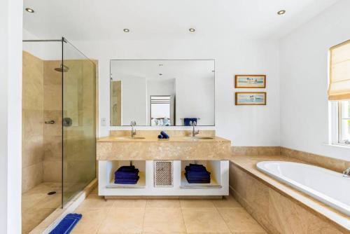 圣彼得教区Blue Horizon Battaleys Mews lovely secure villa 5 minutes from Mullins beach的一间带水槽、浴缸和镜子的浴室